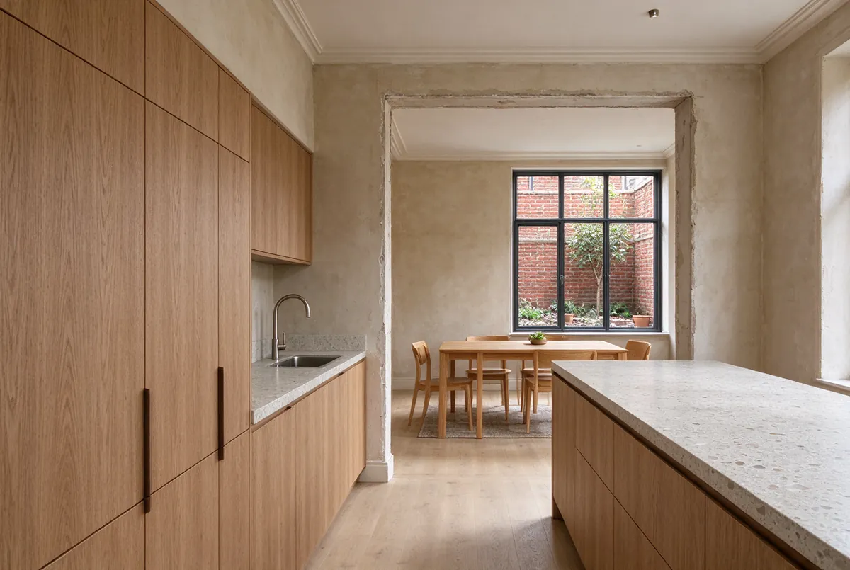 Keuken met houten kasten en eetplaats in een rijwoning