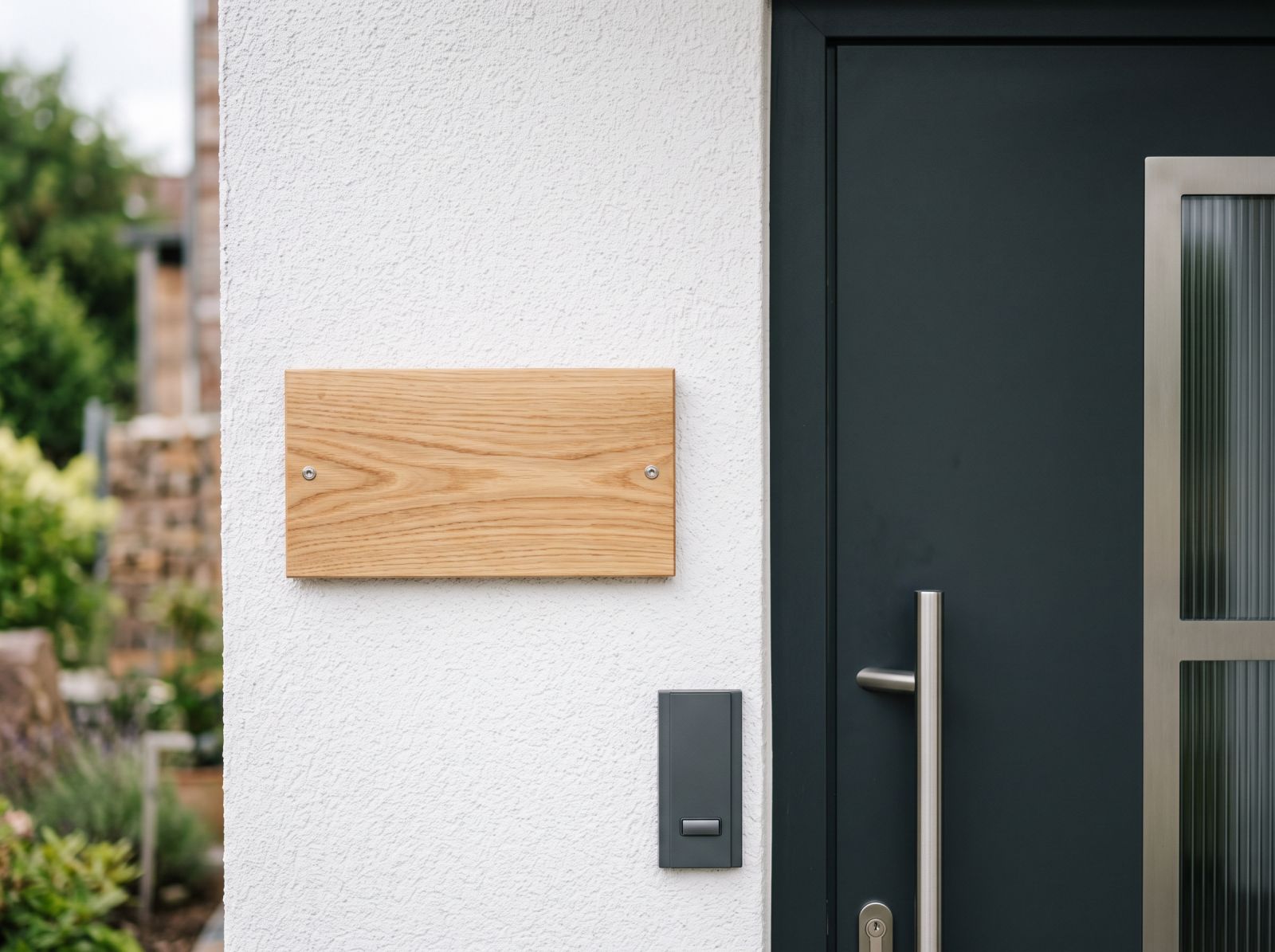 Gegraveerd houten naambord naast een voordeur
